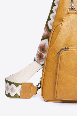 Ochre PU sling bag with a patterned strap and front zip pocket.