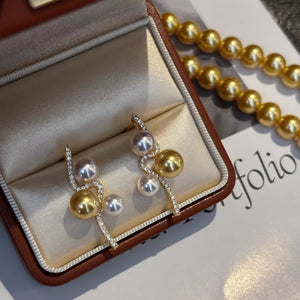 Gold and pearl wave earrings with cubic zirconia accents in a jewelry box.