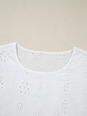 White cotton blouse with delicate eyelet embroidery and a ruffled neckline.