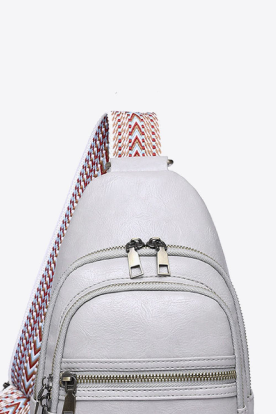 Geometric strap sling bag in Mid Gray with chevron strap detail and double zipper closure.