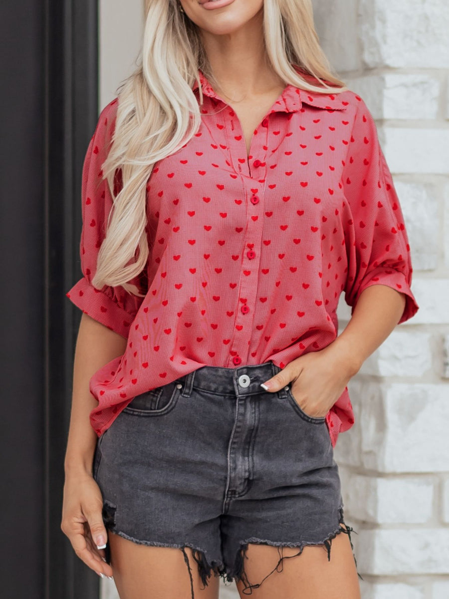 Red button-down shirt with all-over red heart pattern, cuffed sleeves, and classic collar.