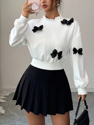 White crew neck sweatshirt with black bow appliques and ruffled collar