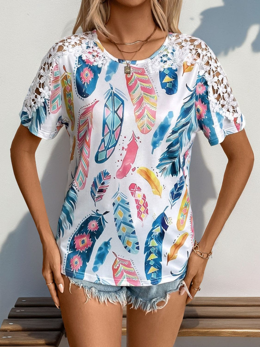White feather print blouse with crochet short sleeves and a scoop neck.