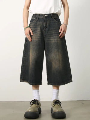 Wide-leg distressed denim culottes in dark wash with frayed hem.