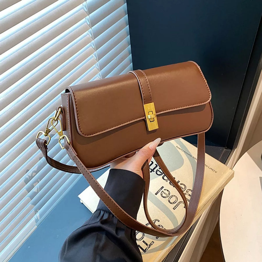 Brown rectangular crossbody bag with gold clasp and adjustable strap.