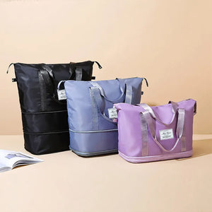 Expandable travel tote bags in black, dusty blue, and lavender with contrast trim and silver straps.