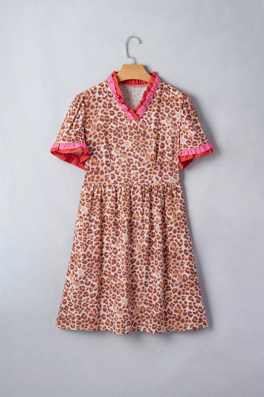 Leopard print dress with ruffled V-neck and short sleeves.