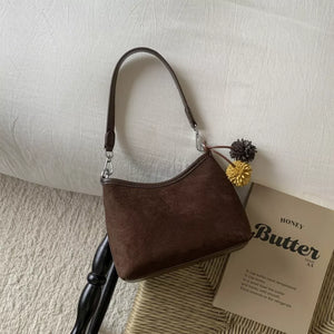 Brown suede crossbody bag with charm and adjustable strap
