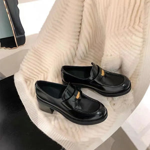 Black patent leather loafers with gold hardware detail and block heel.