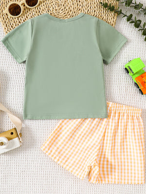 Light green cotton baby tee with embroidered tractor and yellow gingham shorts.