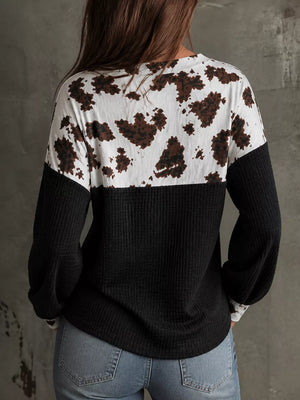 black blouse featuring waffle-knit and cow-print