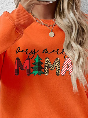 Orange long sleeve sweater with "Very Merry Mama" graphic in plaid, tree, leopard print, and stripes.
