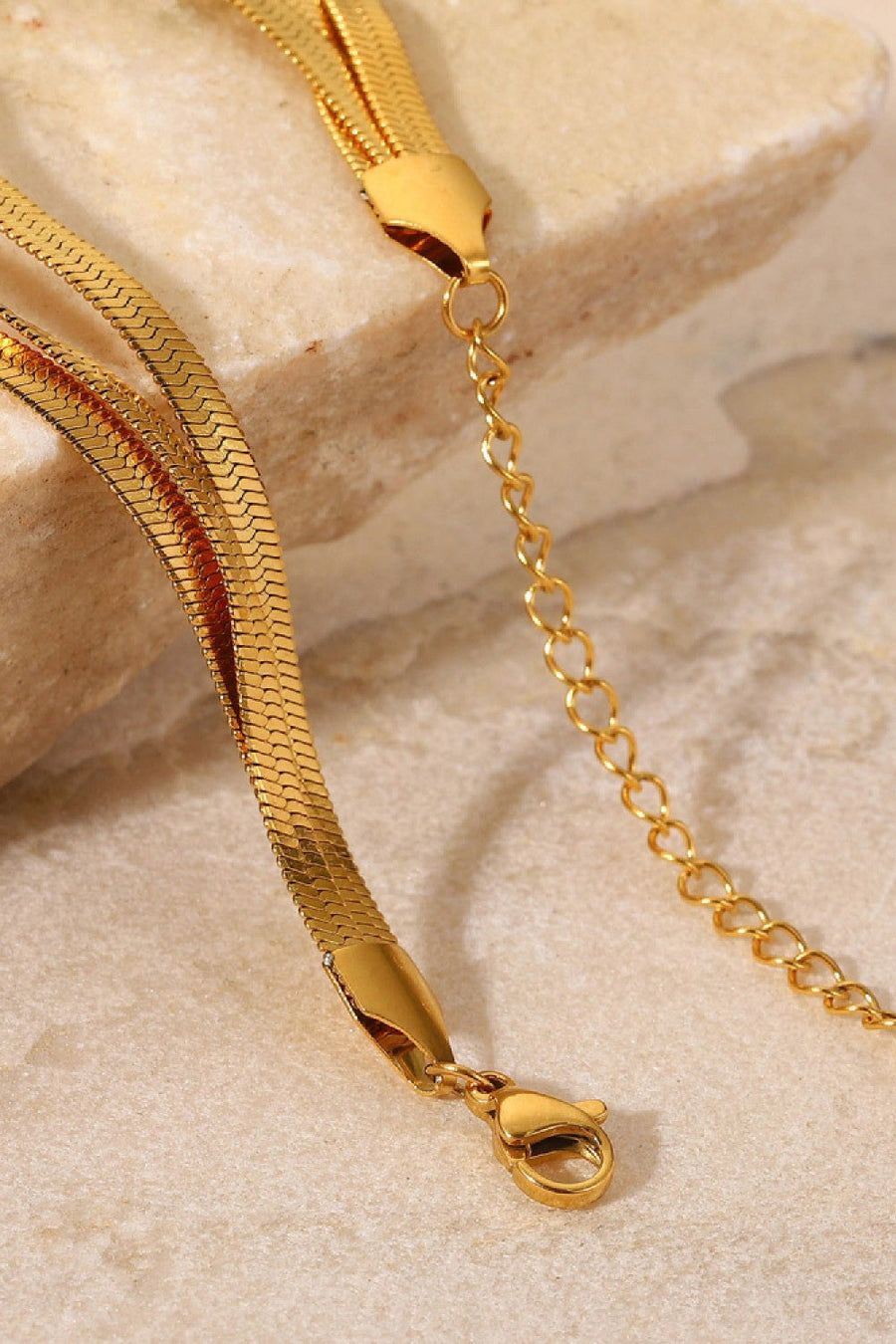 Gold triple herringbone chain bracelet with lobster clasp and extender chain.