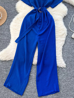 Blue belted wide leg romper with button-down front and fabric tie belt.