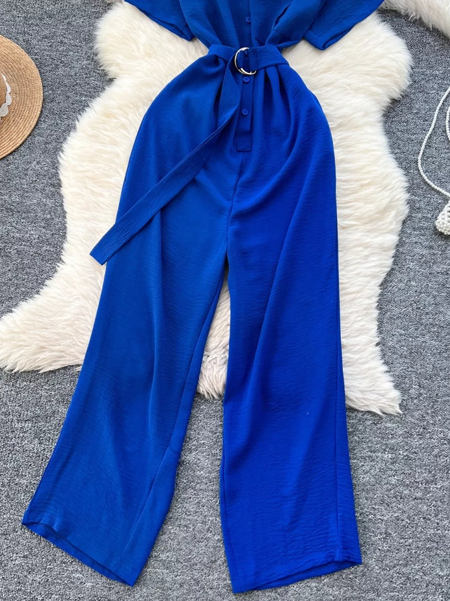 Blue belted wide leg romper with button-down front and fabric tie belt.