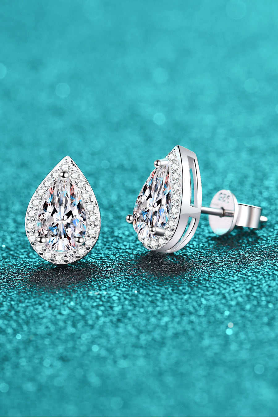 Silver teardrop halo earrings with pavé accents and a central diamond-cut stone.