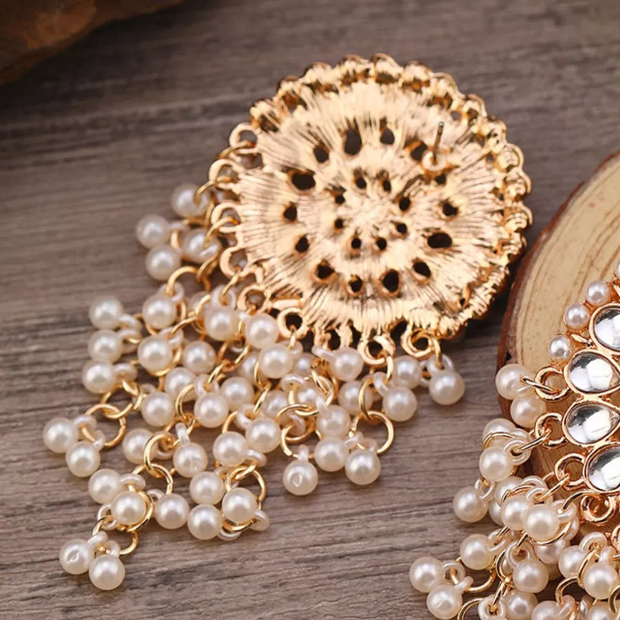 Gold statement dangle earrings with pearl fringe and intricate design.