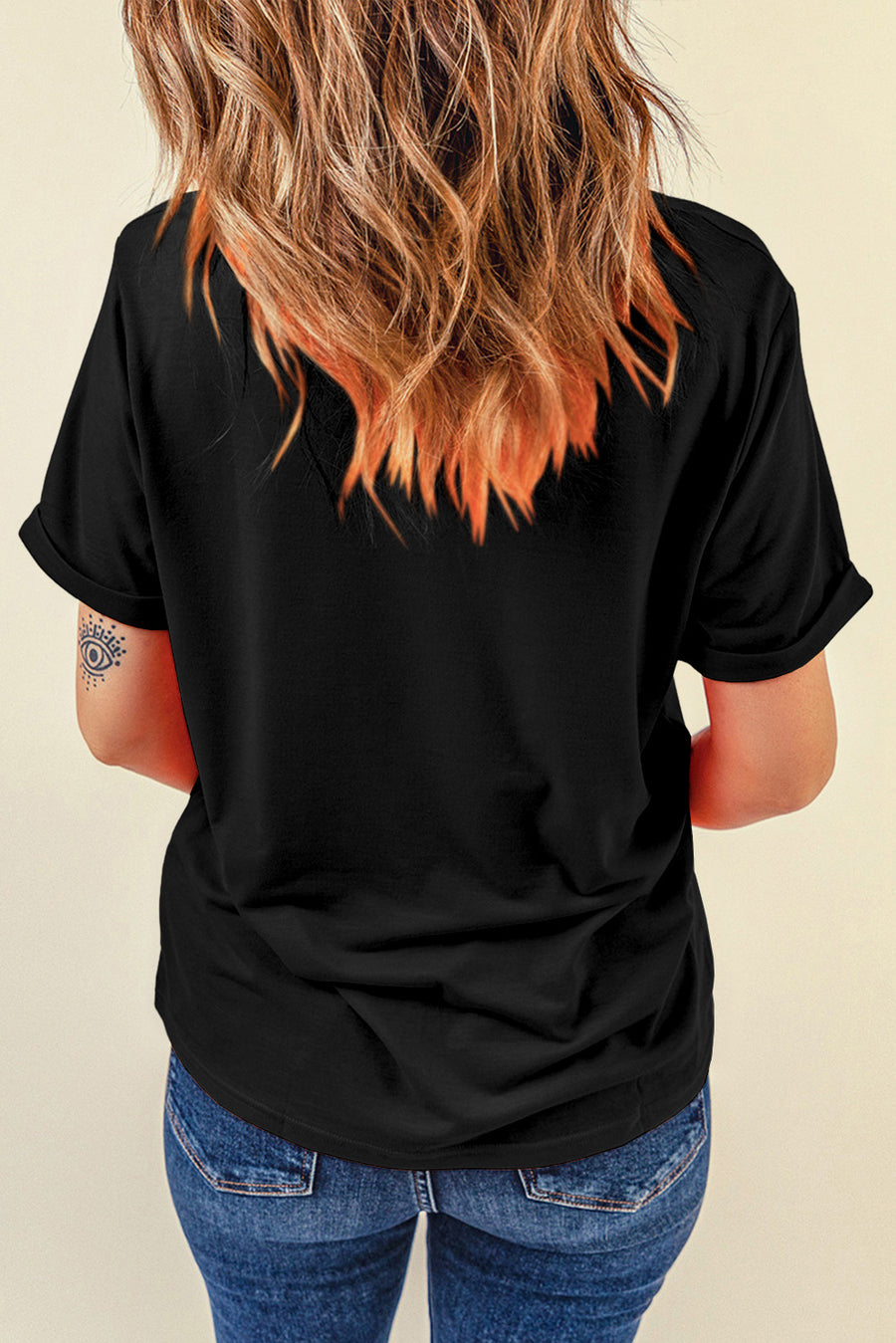Black cotton t-shirt with torn edge American flag graphic and rolled sleeves.