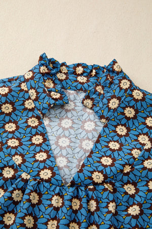 Floral V-neck blouse with ruffled collar and puff sleeves in blue cotton.