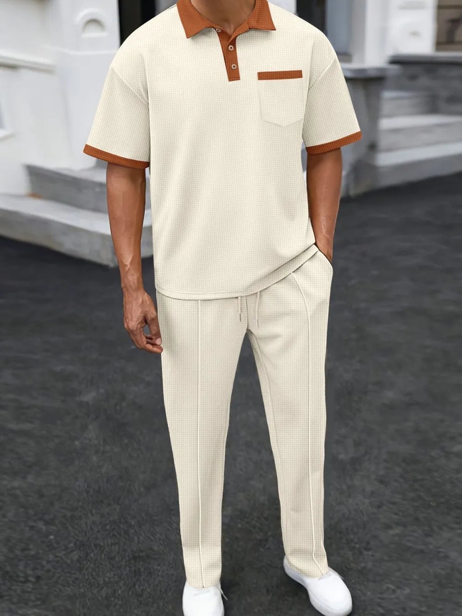 Beige textured polo shirt with contrast collar and pocket, paired with matching track pants.