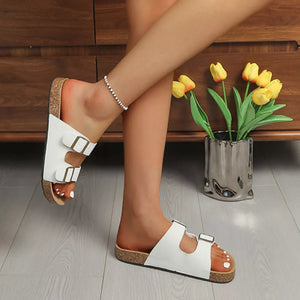 White buckle strap open toe sandals with cork sole and adjustable straps.
