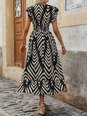 Black and white geometric ruffled midi dress with slit and short sleeves.