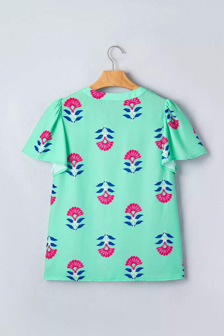 Mint green blouse with pink floral print, V-neck, and flutter sleeves.
