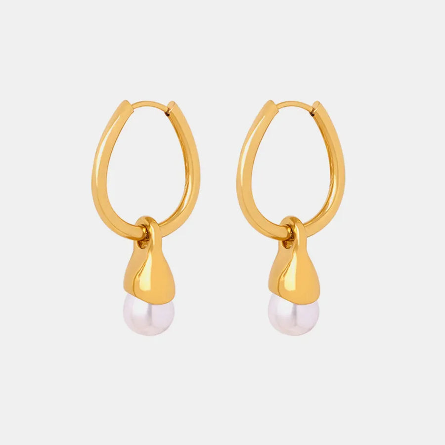 Gold oval hoop earrings with a pearl drop detail.