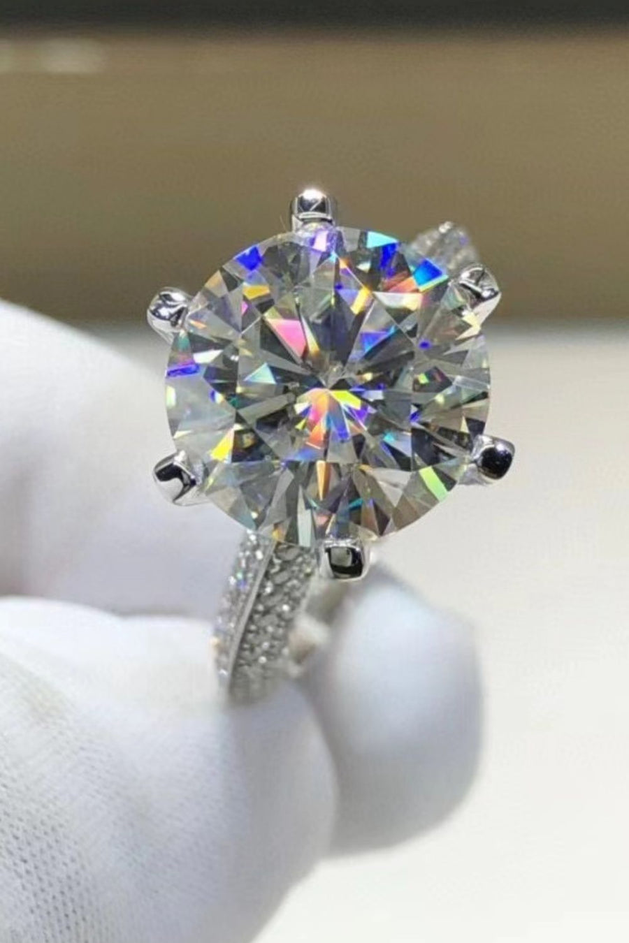Silver pavé band moissanite solitaire ring with a round brilliant cut center stone.