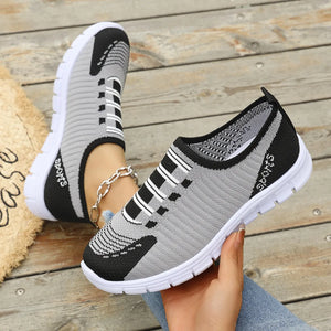 Grey ribbed knit slip-on sport sneakers with black accents and white soles.