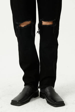 Black denim jeans with distressed knees and a modern straight leg cut.