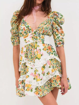 Ruched floral tie-front dress with half sleeves, lace trim, and tiered skirt.
