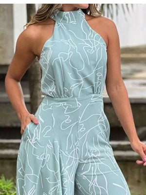 Light blue halter neck romper with abstract white line art print and wide legs.