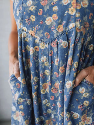 Floral denim overalls with pockets and pleated detail.