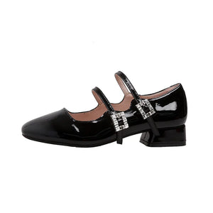 Black patent leather double strap Mary Janes with rhinestone buckles.