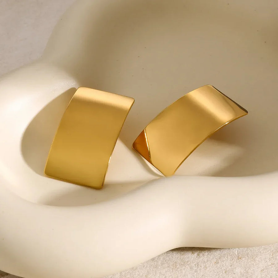 Sculpted gold-tone statement earrings with a bold, curved design.
