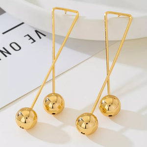 Gold earrings featuring drop design and geometric