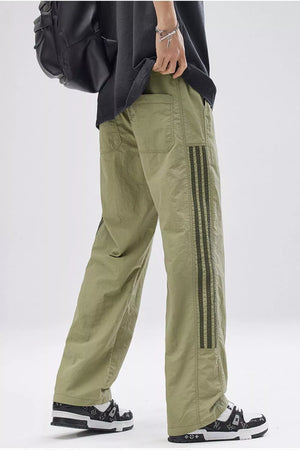 Men's light green wide-leg cargo pants with dark stripe detail on the side.