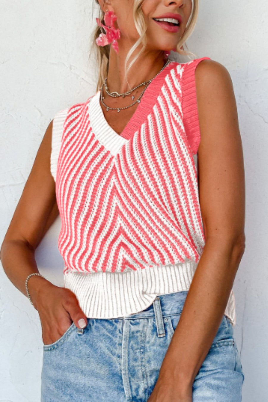 Chevron knit vest with v-neck and colorblock coral and white stripes.