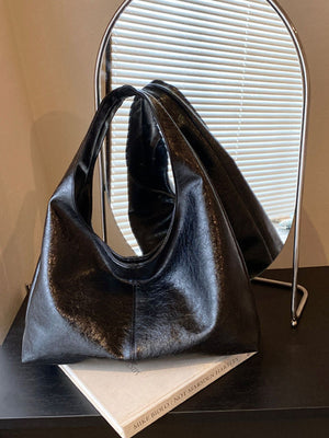 shoulder bag in black featuring shoulder strap and relaxed fit