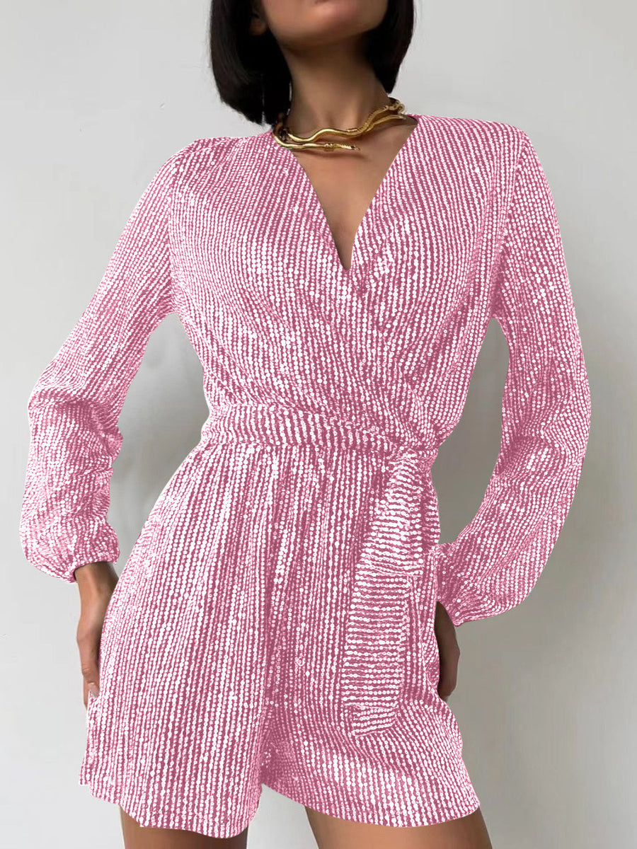 Pink sequin wrap romper with blouson sleeves and a V-neckline.