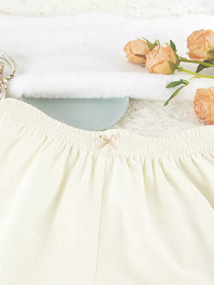 cream pajama set with hip-length top, mini shorts and button-front