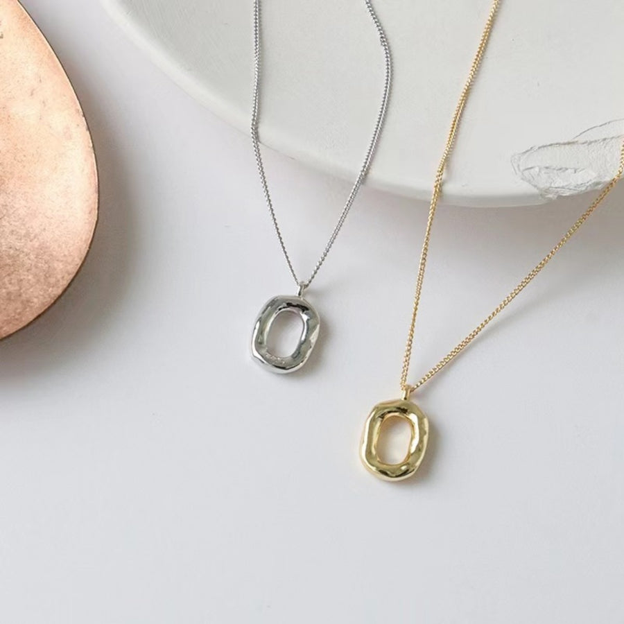 Geometric pendant necklaces in silver and gold with abstract oval pendants.