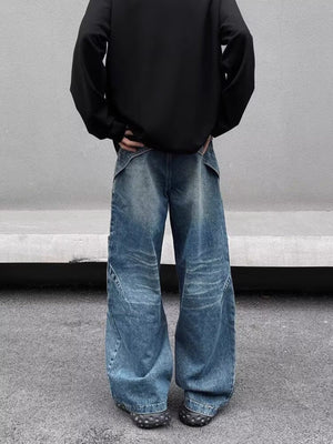 Men's washed blue wide-leg jeans in 100% cotton with distressed detailing and diagonal seams.