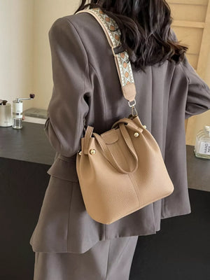 Textured crossbody bag in Khakis with a unique patterned strap.