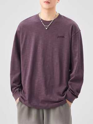 Oversized long-sleeve cotton tee in Sauce Purple with embroidered logo detail.