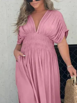 Pink V-neck maxi dress with dolman sleeves, smocked waist, and pockets.