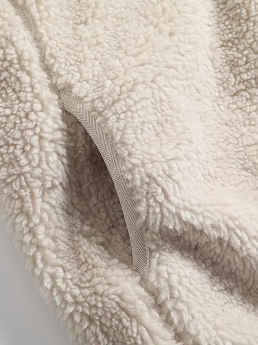 Beige sherpa zip-up jacket with chevron trim pocket detail.