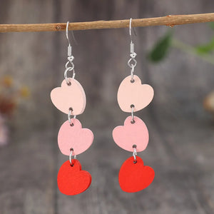 Cascading heartwood dangle earrings in blush pink and red with silver hooks.