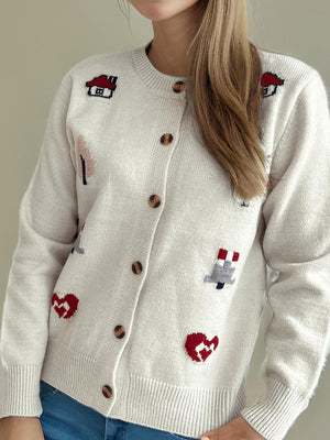 White acrylic button-up cardigan with embroidered houses, trees, and hearts.